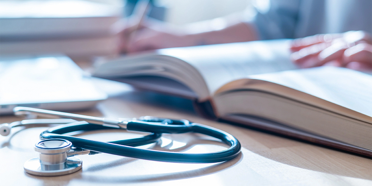 Estetoscópio sobre livro aberto, estudo e ensino em medicina