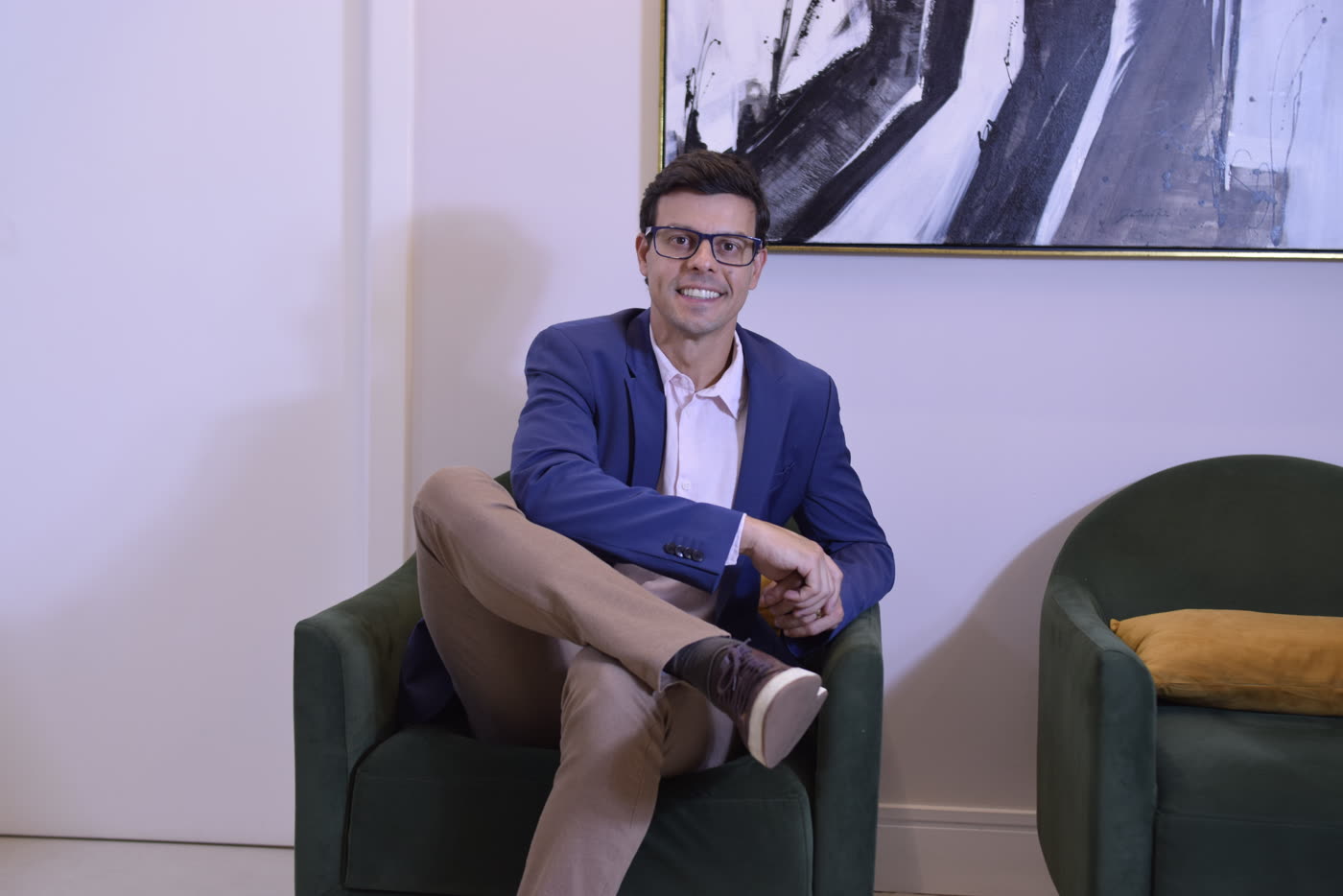 Dr. Ricardo Dolci sentado em poltrona no consultório